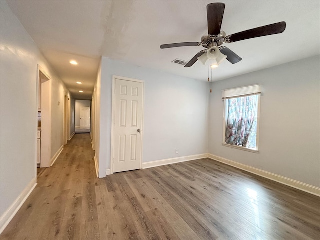 empty room with ceiling fan and hardwood / wood-style flooring