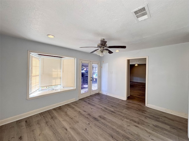 unfurnished room with dark hardwood / wood-style floors, ceiling fan, a textured ceiling, and french doors