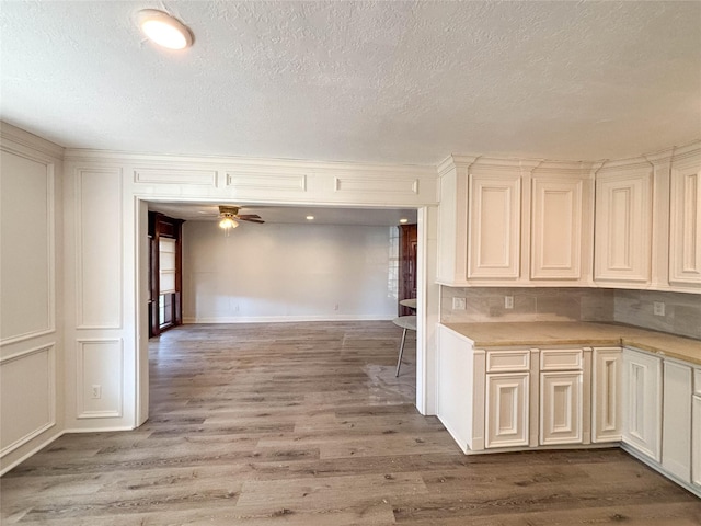 kitchen with a textured ceiling, light hardwood / wood-style floors, and ceiling fan