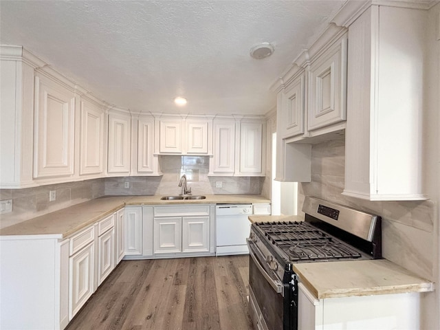 kitchen featuring gas stove, white cabinetry, dishwasher, sink, and hardwood / wood-style floors