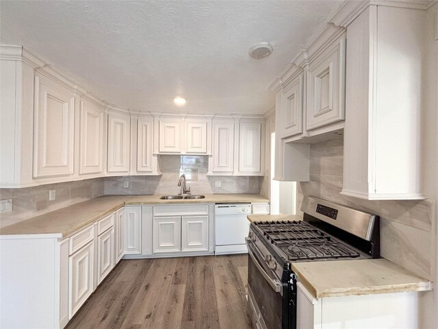 kitchen with gas range, tasteful backsplash, white dishwasher, and a sink