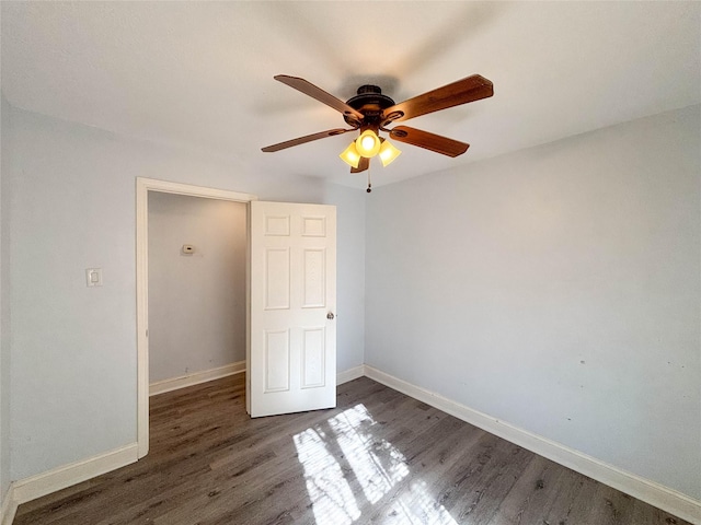 unfurnished bedroom with ceiling fan and dark wood-type flooring