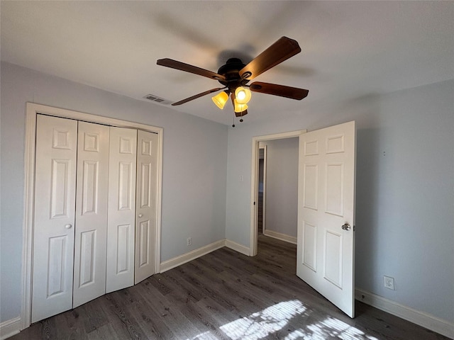 unfurnished bedroom with visible vents, wood finished floors, a closet, baseboards, and ceiling fan