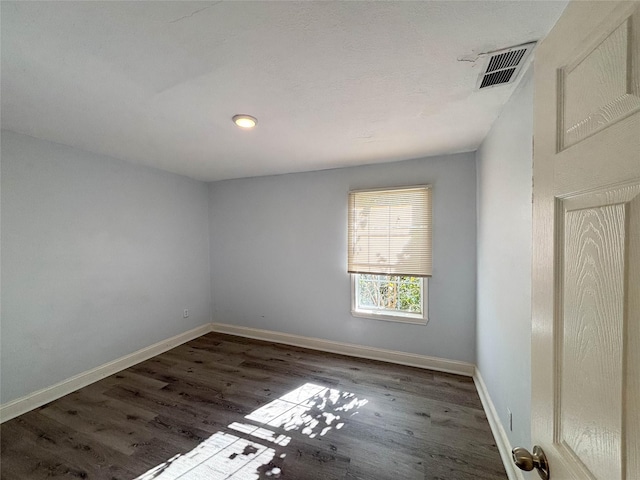 empty room with visible vents, baseboards, and wood finished floors