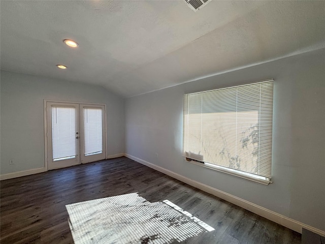 empty room with french doors, dark wood-type flooring, and lofted ceiling