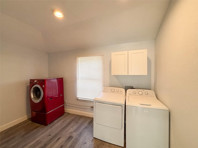 laundry room with dark hardwood / wood-style floors, cabinets, and washing machine and clothes dryer