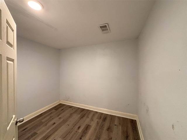 unfurnished room with dark wood finished floors, visible vents, and baseboards