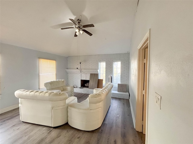 living room featuring hardwood / wood-style floors, ceiling fan, lofted ceiling, and a fireplace