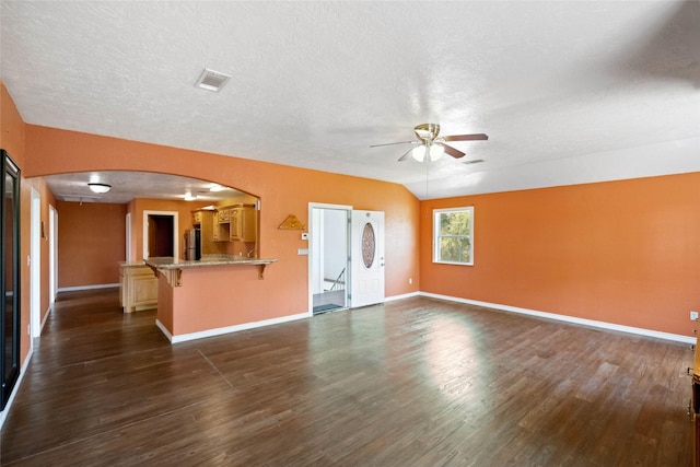 unfurnished living room featuring ceiling fan, lofted ceiling, and dark wood-type flooring