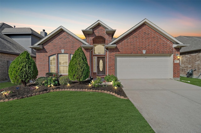 front of property with a yard and a garage