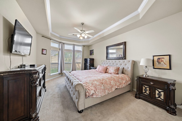 carpeted bedroom featuring ornamental molding, a raised ceiling, and ceiling fan