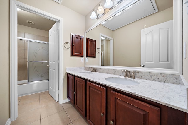 bathroom with bath / shower combo with glass door, tile patterned floors, and vanity