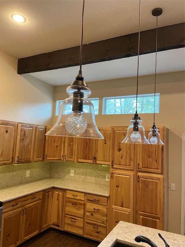 kitchen with dark wood-type flooring, hanging light fixtures, decorative backsplash, beam ceiling, and light stone counters