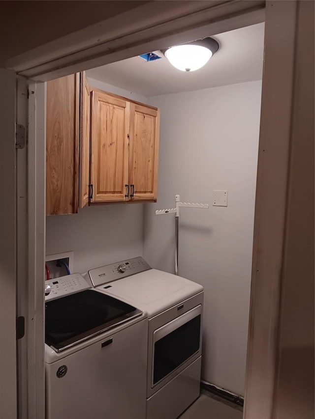 washroom with cabinets and washing machine and clothes dryer