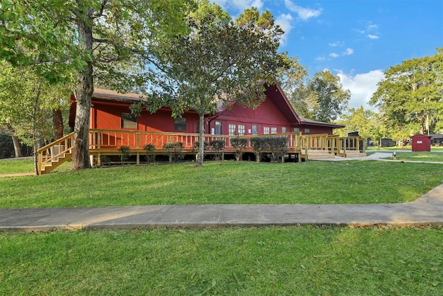 rear view of house with a wooden deck and a yard