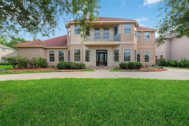 view of front of property with a balcony and a front lawn