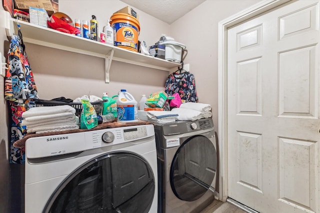 laundry area with a textured ceiling and separate washer and dryer