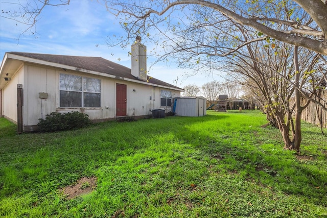 exterior space with a yard, cooling unit, and a shed