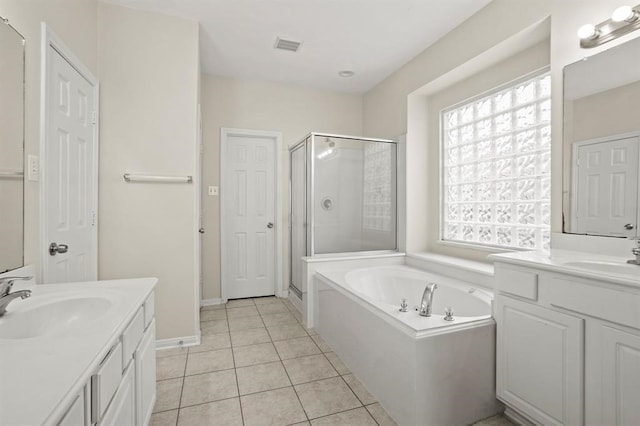 bathroom featuring a bath, a shower stall, tile patterned floors, and a sink