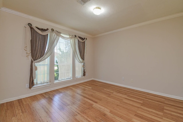 spare room with ornamental molding, a textured ceiling, and light hardwood / wood-style flooring