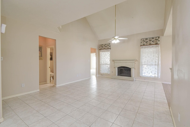 unfurnished living room with ceiling fan, light tile patterned floors, and high vaulted ceiling