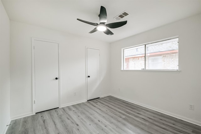 unfurnished bedroom with ceiling fan and light wood-type flooring