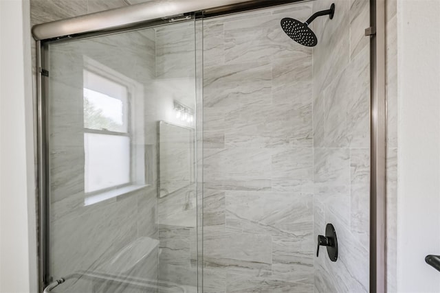 bathroom with a shower with door