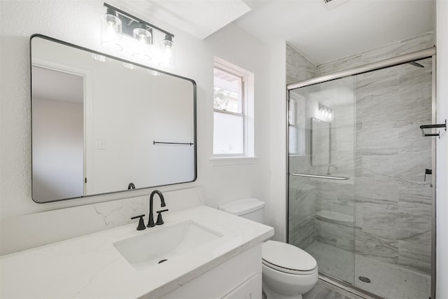 bathroom with walk in shower, vanity, and toilet