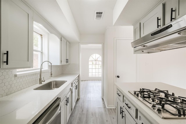 kitchen featuring gas stovetop, sink, and white cabinets