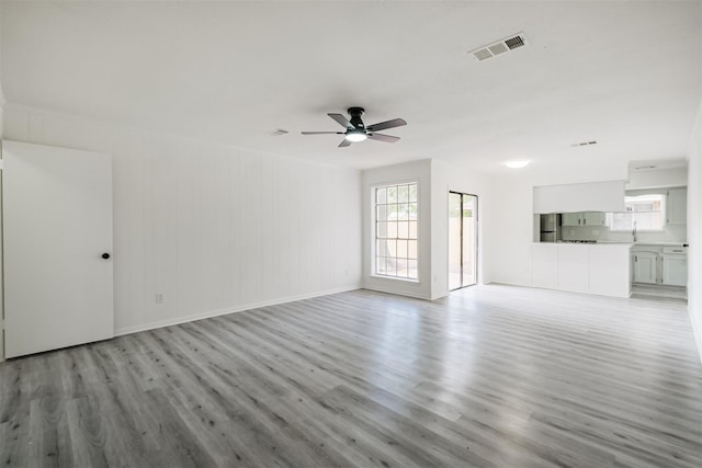 unfurnished living room with ceiling fan and light hardwood / wood-style flooring