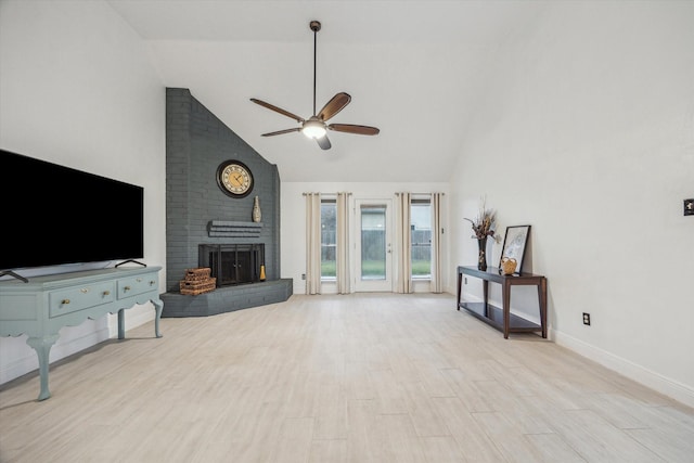 living room featuring ceiling fan, a fireplace, high vaulted ceiling, and light hardwood / wood-style floors