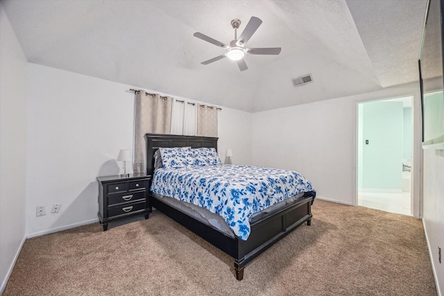 carpeted bedroom with a textured ceiling, connected bathroom, and ceiling fan