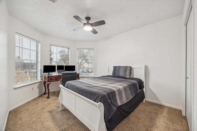 bedroom with carpet flooring, a textured ceiling, a closet, and ceiling fan