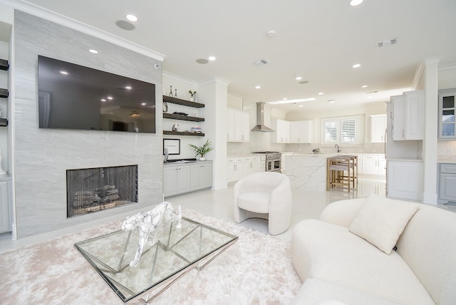 living room with crown molding and a fireplace