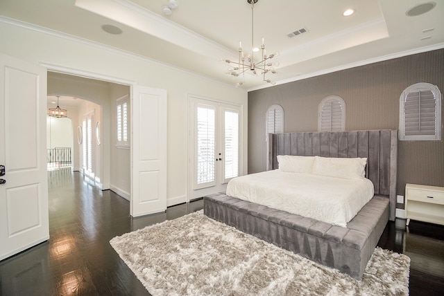 bedroom featuring french doors, crown molding, dark hardwood / wood-style floors, a raised ceiling, and a notable chandelier