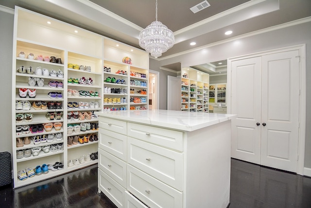 spacious closet featuring an inviting chandelier and dark wood-type flooring