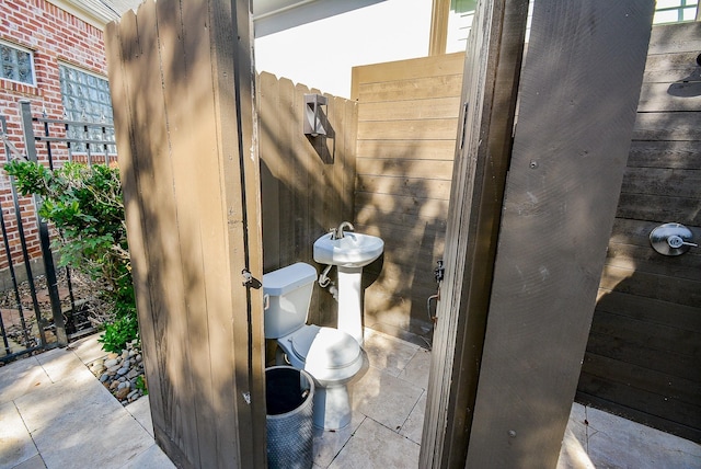 bathroom with wooden walls and toilet