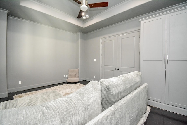 home theater featuring ornamental molding, a raised ceiling, and ceiling fan