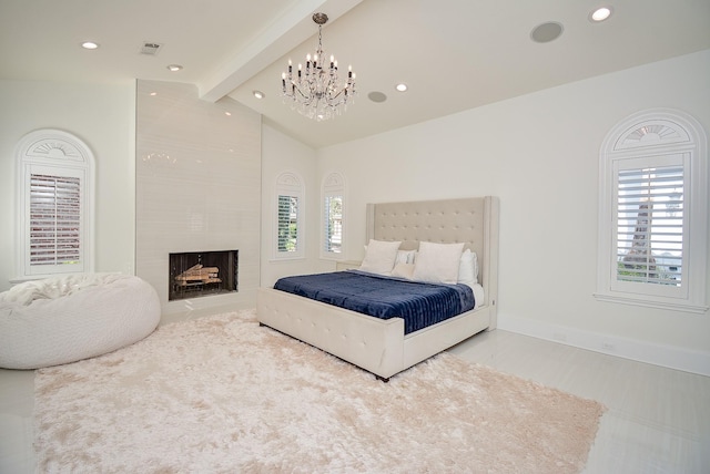 bedroom featuring vaulted ceiling with beams, an inviting chandelier, and a fireplace