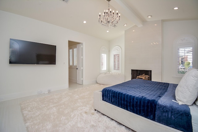 bedroom with vaulted ceiling with beams, a notable chandelier, and a large fireplace