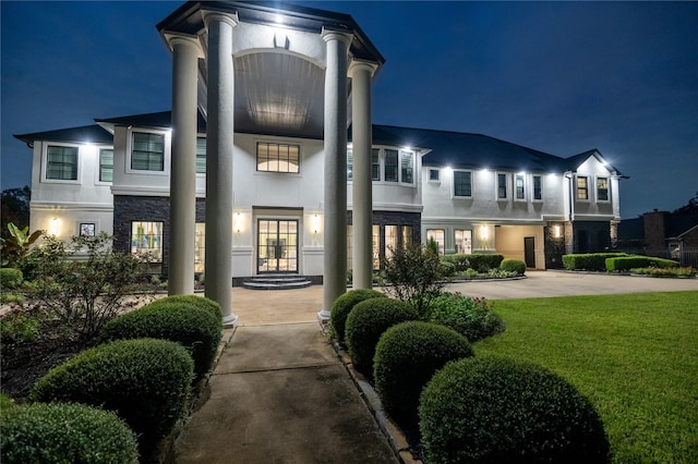 view of front facade featuring a lawn and french doors