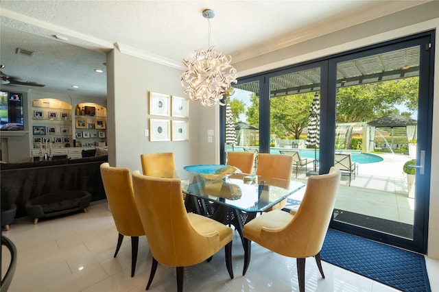 dining space featuring tile patterned floors, a chandelier, a textured ceiling, and ornamental molding