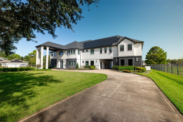 view of front of property with solar panels and a front yard