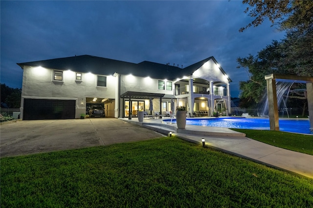 exterior space with a lawn, pool water feature, a balcony, a garage, and a patio