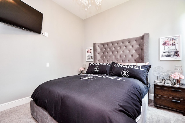 bedroom with light carpet and a chandelier