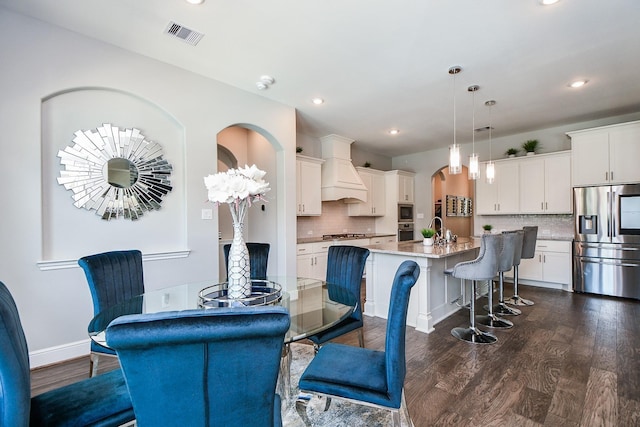 dining space with dark wood-type flooring and sink