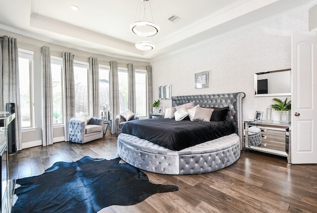 bedroom with a raised ceiling, crown molding, and dark wood-type flooring