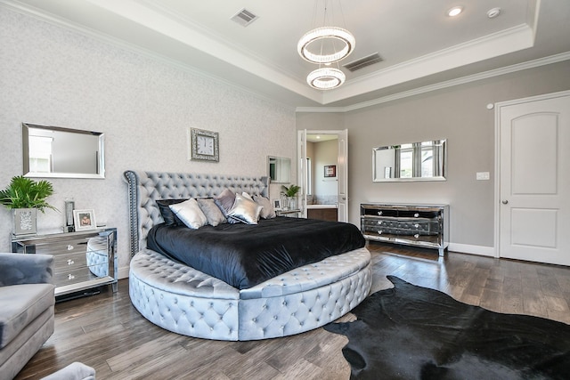 bedroom with hardwood / wood-style floors, a raised ceiling, and ornamental molding