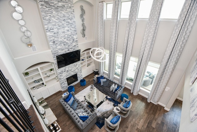 living room with dark hardwood / wood-style floors, a fireplace, a high ceiling, and built in shelves