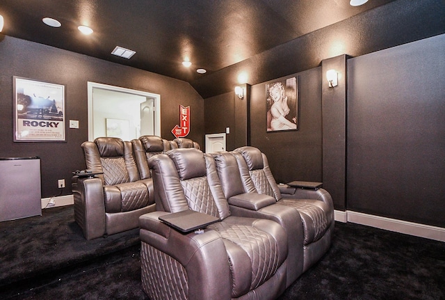 cinema room featuring dark colored carpet and lofted ceiling